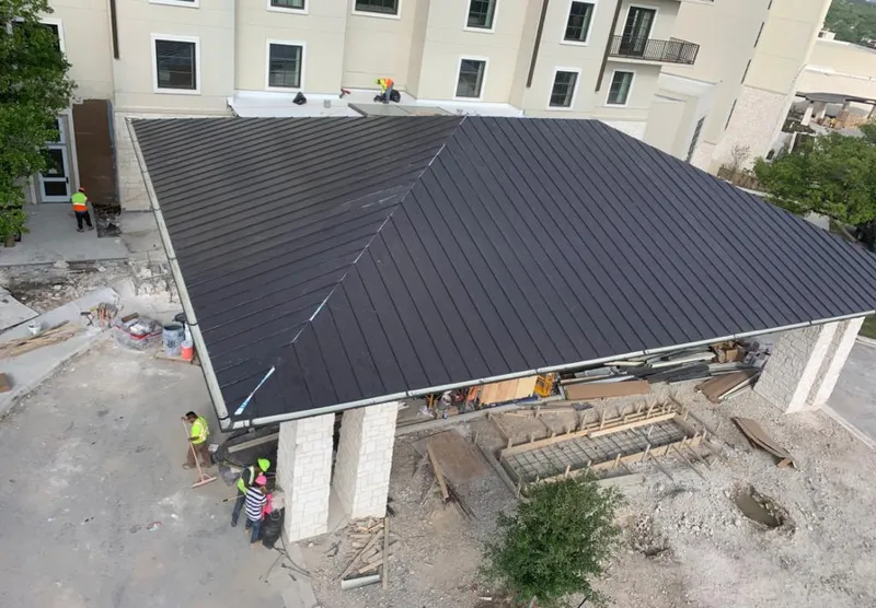 Metal roofing installation team working on a commercial building in Mandeville